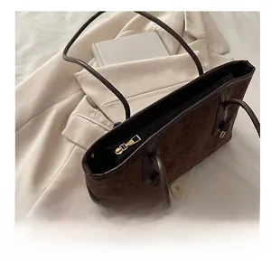 Détail d'un sac cabas imprimé léopard avec fermeture éclair dorée et texture daim