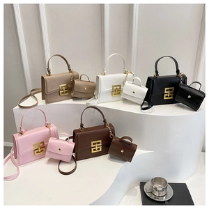Close-up of matte crossbody bags with golden square metal buckles and mini pouches