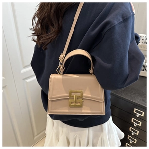 Dettaglio borsa a tracolla beige con chiusura a catena dorata e trama in pelle liscia