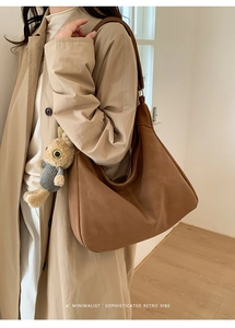 Close-up of retro brown oversized tote bag with plush rabbit charm and stitching detail