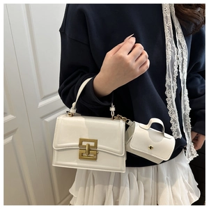 Dettaglio della borsa a tracolla bianca con chiusura dorata e mini pochette coordinata