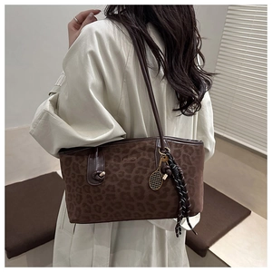 Détail du sac cabas imprimé léopard avec anses en cuir et breloque raquette de tennis