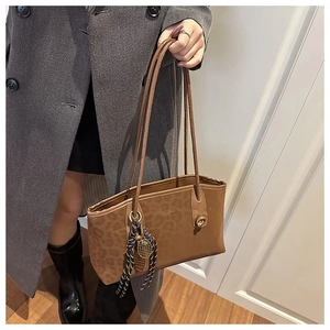 Détail du sac cabas avec gaufrage léopard, pendentif mode et breloque de tennis