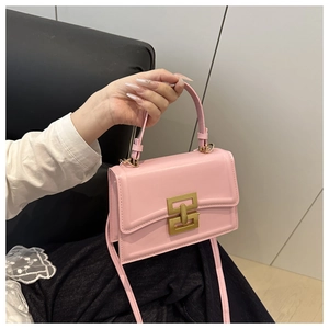Dettaglio della borsa in pelle rosa con chiusura a incastro dorata e tracolla regolabile