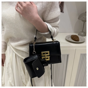Dettaglio della borsa a tracolla nera con fibbia dorata e mini pochette coordinata