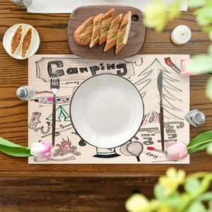 Tovaglietta in lino con illustrazioni da campeggio su tavolo di legno e stoviglie
