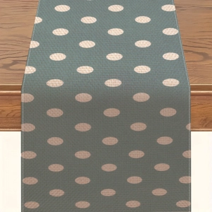 Dettaglio del runner in lino grigio-verde con pois beige su un tavolo in legno