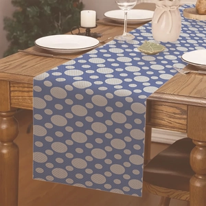 Dettaglio del runner da tavola blu navy con pois grigi posizionato su un tavolo di legno