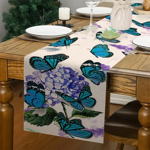 Dettaglio del runner da tavola con iris e farfalle blu su tessuto di lino fine