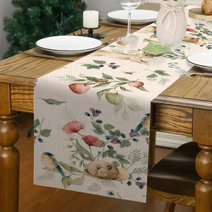 Dettaglio di un runner da tavola in lino rustico con motivi di animali della foresta e fiori