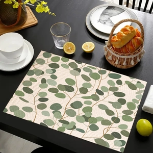 Detailed view of linen placemat with eucalyptus leaf print on a dark wooden dining table
