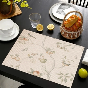Linen placemat with vintage floral and bird prints on a black wooden table setting