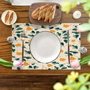 Linen placemat with eucalyptus leaf print on dark wood table with ceramic plate