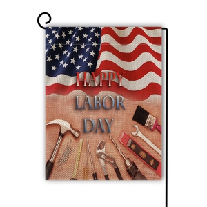 Close-up detail of Happy Labor Day garden flag with tools and linen fabric texture