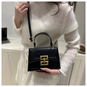 Elegante borsa a tracolla nera con fibbia dorata vintage in un ambiente moderno
