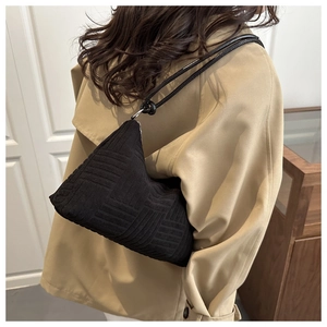 Dettaglio della borsa a tracolla in velluto nero con motivi geometrici jacquard unici