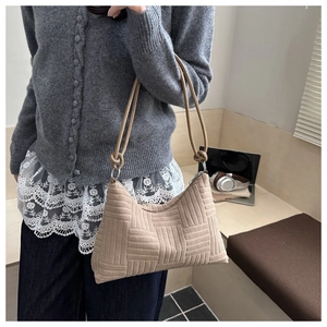Dettaglio della borsa hobo intrecciata beige con tracolla a nodi in ufficio accogliente