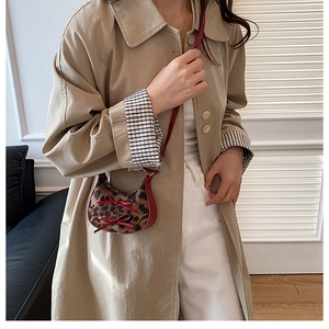Dettaglio mini borsa a mezzaluna leopardata con fiocchi rossi su outfit modella