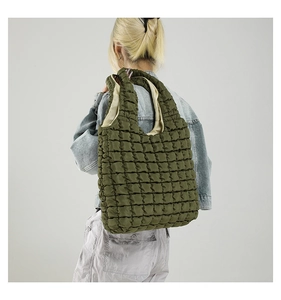 Detail of green quilted puffer tote bag showing soft bubble texture and nylon fabric