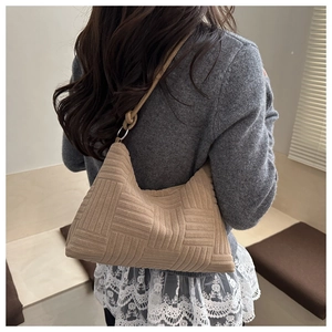 Dettaglio della borsa tote beige con tracolla a nodo e anello in metallo
