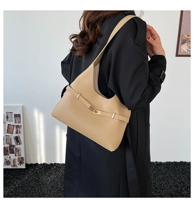 Vista laterale borsa a tracolla beige con fibbia dorata indossata da una modella