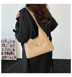 Dettaglio della borsa hobo beige minimalista con fibbia in metallo indossata da una modella