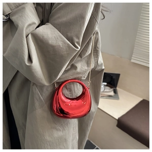 Primo piano dettagliato della mini borsa hobo rossa lucida con catena d'oro e metallo