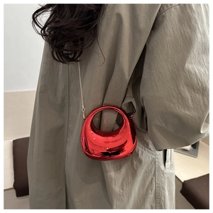 Dettaglio mini borsa rossa metallizzata con catena dorata e finitura a specchio