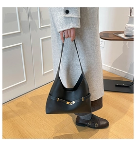 Dettaglio borsa a mano minimalista in pelle nera con fibbia dorata decorativa