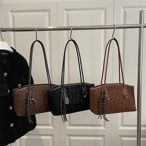 Trois sacs cabas vintage à imprimé léopard suspendus sur un présentoir métallique