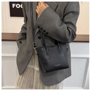 Detail of black leather tote bag with Fashion & Bag engraving and adjustable strap