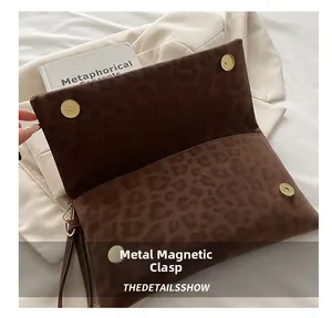 Dettaglio della pochette leopardata in pelle scamosciata con chiusure magnetiche dorate lucide