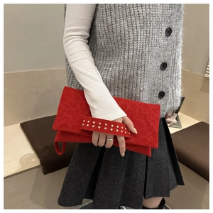 Dettaglio della pochette in camoscio rosso con borchie dorate e texture leopardata