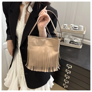 Detail shot of beige PU leather shoulder bag featuring dense tassel fringe decoration