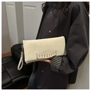 Dettaglio borsa in ecopelle bianco avorio con motivo leopardato e borchie in metallo