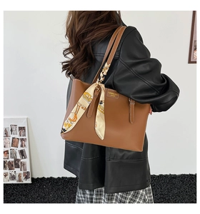 Brown faux leather tote bag with decorative scarf shown in a stylish commuting scene