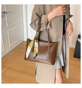 Brown faux leather tote bag detail with decorative geometric silk scarf on handle