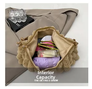 Internal capacity of camel plush shoulder bag showing umbrella, sunglasses and perfume