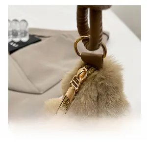 Detail of plush brown shoulder bag with smooth golden metal zipper and leather handle
