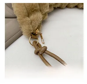 Detail of caramel plush hobo bag with knotted leather strap and white decorative stitching