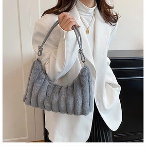 Detail of grey plush shoulder bag featuring soft pleated faux fur and elegant knotted strap