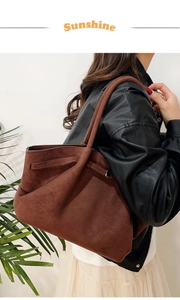 Détail d'un sac cabas en daim marron foncé avec grande capacité et lanières latérales