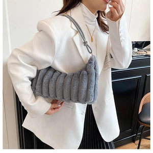 Detailed view of grey faux fur shoulder bag with vertical stripe texture on female model