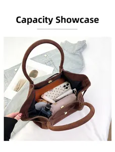 Vue de dessus du grand intérieur du sac cabas en daim marron avec objets du quotidien