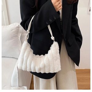 Detail of white faux fur shoulder bag with soft plush texture and elegant knot strap detail