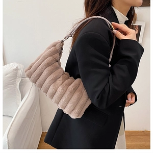 Close-up of fluffy faux fur shoulder bag with horizontal stripe texture and metal rings