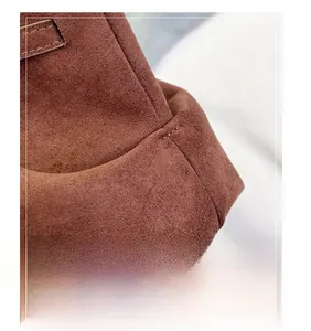 Vue macro du suède caramel foncé et des coutures précises sur le sac cabas à ailes