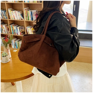 Vue détaillée d'un grand sac cabas marron mat avec lacets latéraux dans un café cosy