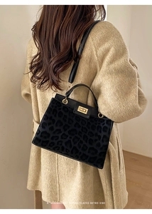 Close-up of retro leopard print bucket bag with gold twist lock and elegant texture