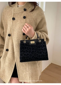 Detail of leopard print handbag with gold circular handle and twist lock closure